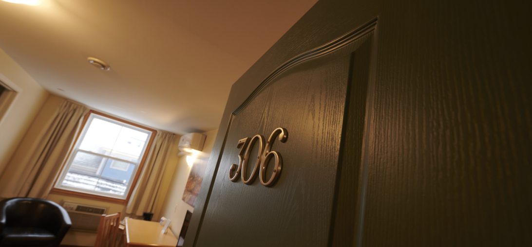 Green door with golden numbers reading 306