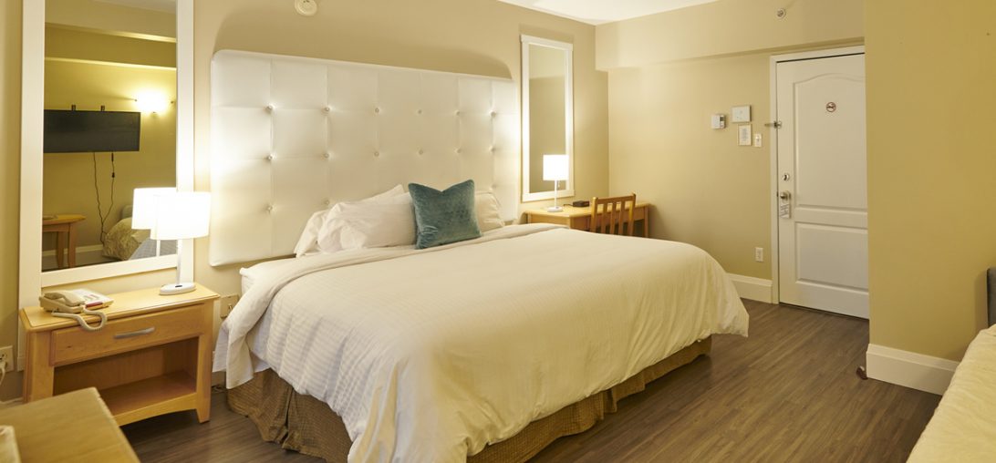 King Sized bed with two side tables and large mirrors in Room 206