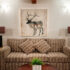 a patterned couch sat in front of an abstract painting of a deer at the Smuggler’s Cove Inn.