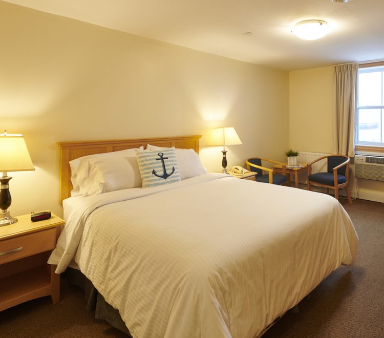 a Queen sized bed with a blue and white anchor pillow in room 311